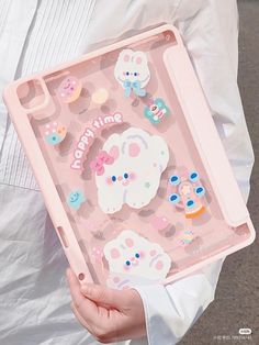 a person holding a pink tray with stickers on it