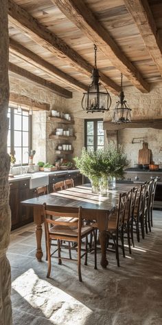 an old fashioned kitchen and dining room with stone walls, exposed beams and wood flooring