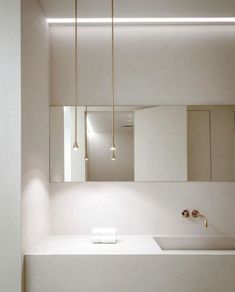 a bathroom with a sink, mirror and lights