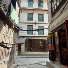 an alley way with buildings and shops in the background