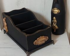 two black vases sitting next to each other on a white counter top with gold accents