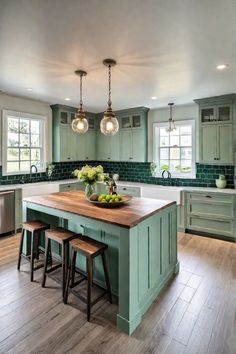 a large kitchen with green cabinets and wooden counter tops, along with two stools