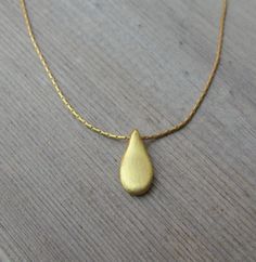 "This hand made teardrop pendant necklace has an effortless, earthy allure. The matte 18k gold plated brass pendant hangs at the base of a delicate 14k gold filled chain. This is the perfect necklace to pair with any casual outfit adding a bohemian vibe. Wear this alone, or layer it with your other favorites for a personalized eclectic look. ❉ F A C T S total length : 16\"/ 42 cm teardrop length: 1\"/ 2.54 cm teardrop width: 0.45\"/ 1.1 cm You will receive the necklace in a gift box ready to be Gold Bohemian Teardrop Pendant Drop Necklace, Bohemian Gold Teardrop Pendant Drop Necklace, Gold Drop Bohemian Necklace, Bohemian Gold Teardrop Pendant Necklace, Bohemian Gold Drop Necklace, Everyday Handmade Teardrop Necklace, Handmade Gold Teardrop Drop Necklace, Minimalist Handmade Teardrop Pendant Necklaces, Handmade Minimalist Teardrop Pendant Necklace