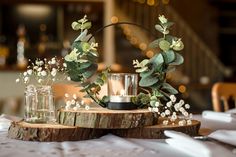 the table is set with candles, flowers and greenery for an elegant centerpiece