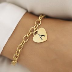 Introducing our 18k Disc Gold Plated Initial Bracelet--a perfect blend of elegance and personal flair. This stunning bracelet features a delicate heart pendant, measuring 20mm x 20mm, crafted from 18k gold-plated stainless steel. Whether you're treating yourself or finding a special gift, this piece combines timeless charm with modern durability. This bracelet is not only a stylish accessory but also practical. It's waterproof and hypoallergenic, making it a great choice for everyday wear. The 1 Classic Heart Bracelet For Valentine's Day Gift, Personalized Dainty Yellow Gold Heart Bracelet, Personalized Yellow Gold Dainty Heart Bracelet, Gold Heart Charm Bracelet Classic Style, Classic Gold Charm Bracelet With Heart, Gold Bracelets With Heart Charm As A Gift, Gold Round Charm Bracelet For Valentine's Day, Gold Name Bracelet With Heart Charm For Anniversary, Gold Bracelets With Heart Charm For Gift