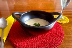 a bowl of soup on top of a red place mat