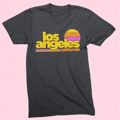 Free Shipping!! Part of our Radical States series, the Los Angeles Sunset shirt is a tribute to old school LA. A retro style and vintage inspired graphic tee printed on a very comfortable, nicely fit shirt. Heather Dark Grey vintage style tee. Men's / Women's / Unisex We use shirts and tanks from companies dedicated to ethical standards of conduct. They are child labor free and sweat shop free. The printing uses inks that are water based and eco-friendly. View our full store: https://www.etsy.co 90s Graphic Tees Vintage, Surf California, Los Angeles Sunset, Retro Shirt Design, Express Outfits, Sunset Shirt, La Style, California Shirt, Beach Vintage