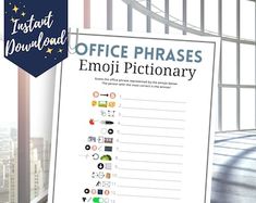 office phrases emoj pictionary displayed in front of window with cityscape