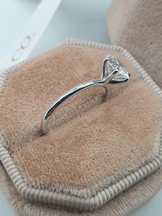 a diamond ring sitting on top of a cushion