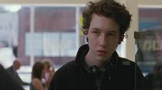 a young man with curly hair wearing headphones