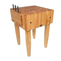 a small wooden table with several knives on it's legs and two holes in the top