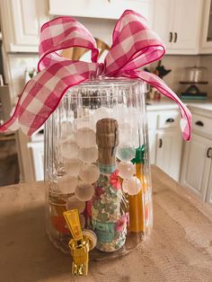 a glass jar filled with lots of bottles on top of a table