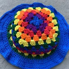 a multicolored crocheted hat sits on the ground