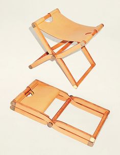 two wooden folding chairs sitting next to each other on a white surface and one chair is empty