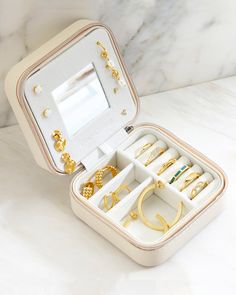 You've got a great jewelry collection. Now, you can take it with you safely wherever you go! Store earrings, rings, necklaces, and more in this convenient and chic travel case. Materials: Faux leather, microsuede, metal zipper Features: 3.75" width x 3.75" length x 1.8" height, eight holes for earrings, three necklace hooks with pockets, metal zipper closure Portable Gold Jewelry Storage For Travel, Gold Rectangular Jewelry Storage For Everyday, Elegant Compact Travel Jewelry, Rectangular Gold Jewelry Storage For Everyday Use, Elegant Gold Jewelry Storage For Travel, Jewelry Travel Case, Store Earrings, Necklace Hooks, Three Necklaces