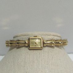 Vintage from the 1950s and pre-owned is this ladies Benrus Cuff Wristwatch. The watch has wonderful Art Deco styling and is completely 10 KT gold filled, it is marked/etched on both the watch case and cuff bracelet. It is manual wind, no batteries. The sturdy cuff opens/expands to fit a small wrist, 6 - 7", is very secure when on and is in very good condition. The watch bezel, face, crystal and crown are all in very good condition. On the watch face is written, "Benrus" at the top and "Swiss" at Luxury Antique Watch Accessories For Anniversary, Luxury Art Deco Jewelry And Watches For Women, Luxury Art Deco White Gold Watch, Vintage Watch Women Cartier Tank, Luxury Vintage Watches With Tachymeter, Vintage Gold Cocktail Watch, Luxury Vintage Watch Accessories With Stainless Steel Clasp, Adjustable Vintage Watch Accessories, Vintage Ladies Watch