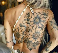 a woman with flowers on her back and tattoos