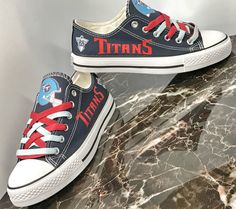 pair of sneakers with titans logo on them sitting on marble countertop next to wall