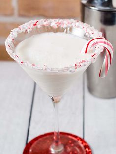 a white drink with candy cane on the rim