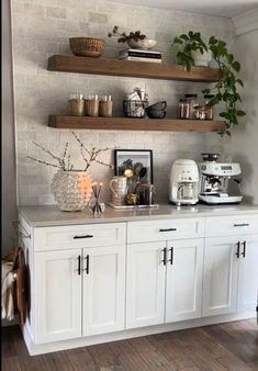 a kitchen with white cabinets and shelves filled with plants, coffee maker, blender and other items