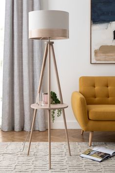 a living room scene with focus on the floor lamp and yellow chair in the foreground