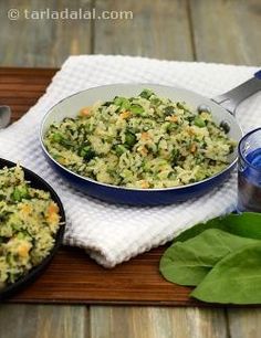 a bowl filled with rice and vegetables on top of a wooden table next to a glass of water