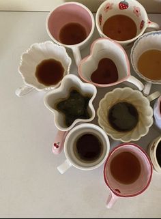 there are many cups with different types of teas in them on the counter top