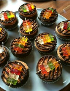 there are many cupcakes with candies on the top and chocolate icing