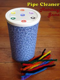 a blue cup sitting on top of a wooden floor next to some colorful yarns