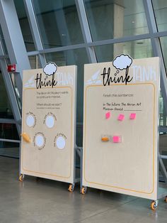 two signs with sticky notes attached to them in front of a glass wall that says think tank