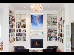 a living room filled with furniture and a fire place in front of a book shelf