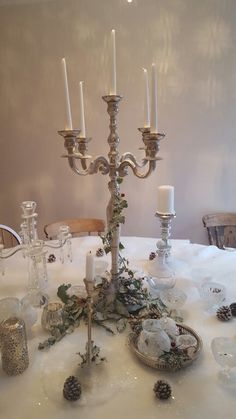 a candelabra with candles on top of it sitting on a white table cloth