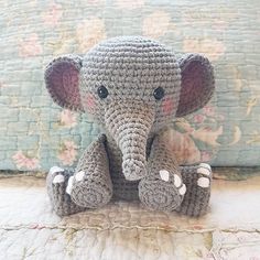 a crocheted elephant sitting on top of a bed