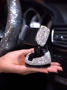 a person holding a car phone holder in their hand with glitter on the inside of it