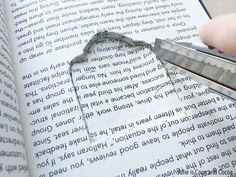 a person is cutting through the pages of a book with a pair of scissor