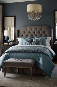 a bedroom with blue walls and a large bed in the middle, along with a bench