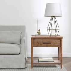 a living room with a couch, table and lamp on the floor next to it