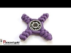 a purple roped toy with a black ball on it's center and an eyeball in the middle