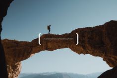 a man standing on top of a large rock formation