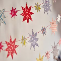 colorful paper stars are hanging from a string