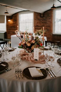 the table is set with place settings and candles