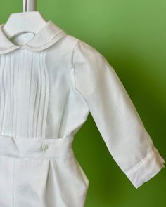 An elegant two-piece set for baby boys to wear during any special occasion. The top has a peter pan collar, handmade pleats, and long sleeves; it has buttons on the back for closure. The bottom is bubbles with buttons on the sides for closure and an elastic band on the back. The interior, or lining, is made with cotton fabric, while the exterior is with white organza. Dry clean 2 piece set Interior: 100% cotton; exterior: 100% polyester Made in Spain Final Sale Bubble Outfit, Christening Outfits, White Shorts Outfit, Bubble Clothes, Boy Baptism Outfit, Baptism Outfit, Long Sleeve Outfits, Spanish Fashion, Christening Outfit