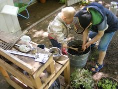 a man and a child are in the yard with some potted plants on a table