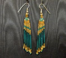 This is a pretty vintage dangle style pierce set of earrings.  Made of different sized glass beads, they're very eye catching. There are mini glass green and gold round beads, 1/8" straight gold beads and 1" long green beads.  They are strung in a cascading effect.  The ear wires are extra long silver.  They're in excellent condition. Green Crystal Drop Earrings With Dangling Beads, Elegant Green Beaded Earrings With Gold Beads, Green Beaded Earrings With Round Beads, Green Long Drop Jewelry With Dangling Beads, Elegant Turquoise Earrings With Gold Beads, Gold Long Drop Beaded Earrings With Ear Wire, Gold Dangle Earrings With Colorful Beads, Green Dangle Beaded Earrings With Gold Beads, Gold Czech Glass Beaded Earrings For Party