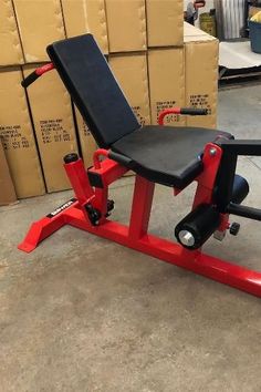 a red bench sitting on top of a floor next to boxes