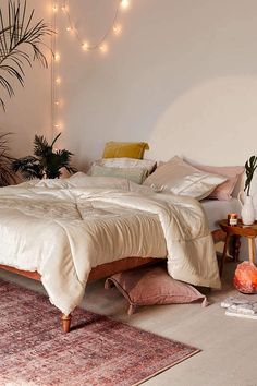 a large bed sitting in a bedroom next to a plant