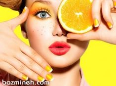 a woman holding an orange up to her face