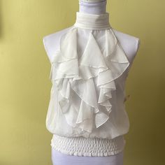 Pink Collection Nwt Beautiful Ivory Ruffled Front Sleeveless High Neck Blouse With Gathered Elastic Bottom, Key Hole Closure Size M, Machine Washable Chic Sleeveless Blouse With Ruffles, Cream Ruffled Top For Party, Elegant Sleeveless White Blouse, White Ruffled Tank Top For Party, White Sleeveless Chic Blouse, Chic White Sleeveless Blouse, Sleeveless Cream Top With Ruffles, Cream Sleeveless Top With Ruffles, White Fitted Ruffle Tank Top