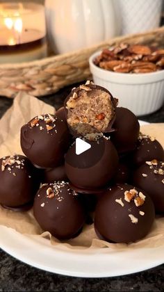 some chocolates are stacked on top of each other with nuts and pecans in the background