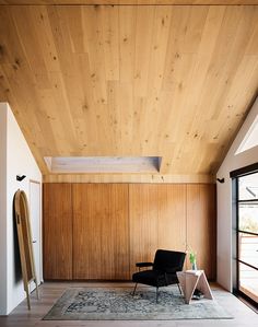 a room with wood paneling and a black chair